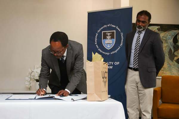 UCT Faculty of Law Dean Danwood Chirwa signing the MOU