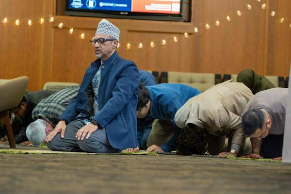 Dr. Rashied Omar leads a group in evening prayers during the interfaith dinner.