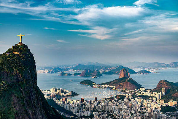 Aerial view of Rio de Janeiro, Brazil, with Christ the Redeemer statue atop Corcovado Mountain overlooking Guanabara Bay and Sugarloaf Mountain.
