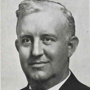 Halftone portrait of a smiling man with light-colored hair, neatly combed back, wearing a dark suit jacket and a patterned bow tie, looking directly at the viewer.