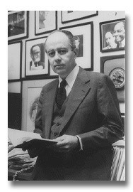 Black and white portrait of Robert Blakey in a dark suit, holding an open book, looking forward seriously.